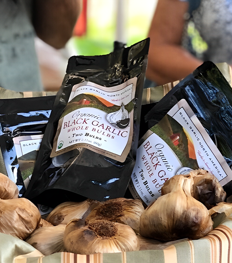 Person about to take a large bite of a gourmet burger with black gloves on.